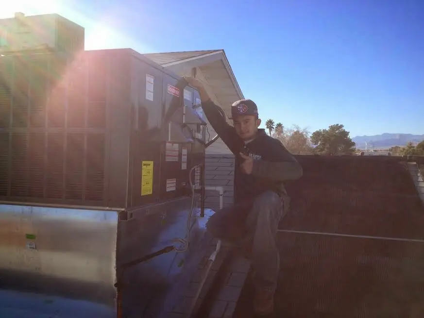 HVAC technician performing Heat Pump Repair on a rooftop unit in Dayton